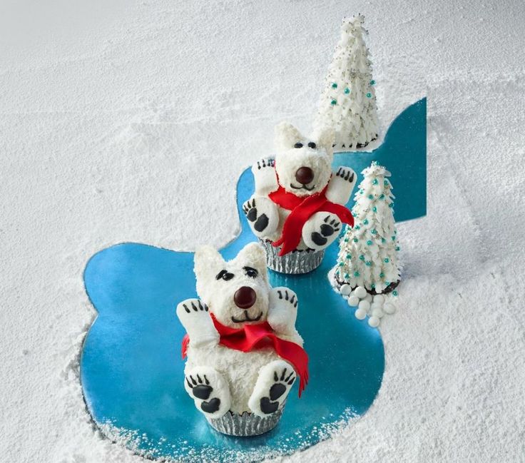 two white teddy bears sitting next to each other in the snow with christmas decorations around them