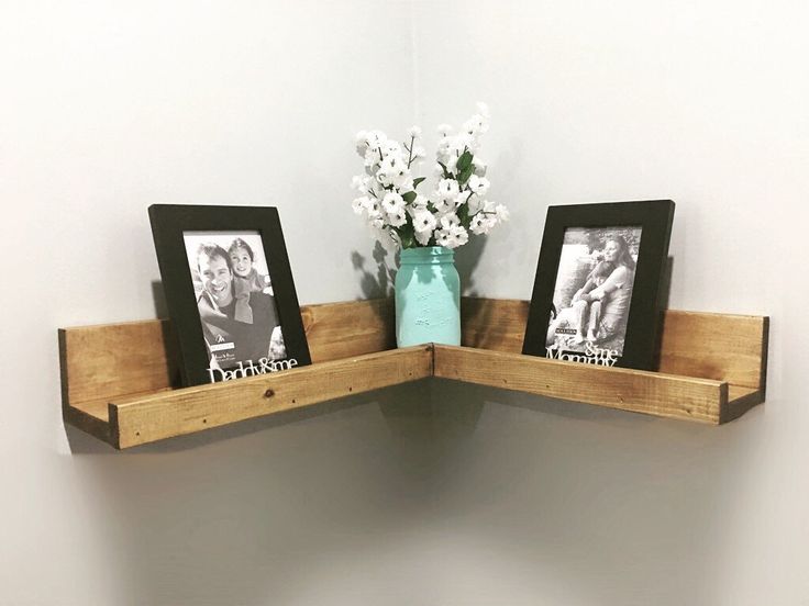 two wooden shelves with pictures and flowers on them