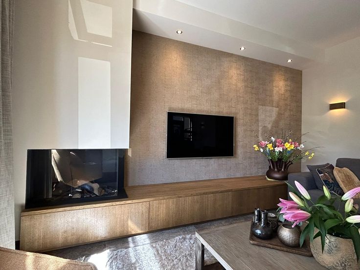 a living room filled with furniture and a flat screen tv mounted on a wall above a fireplace