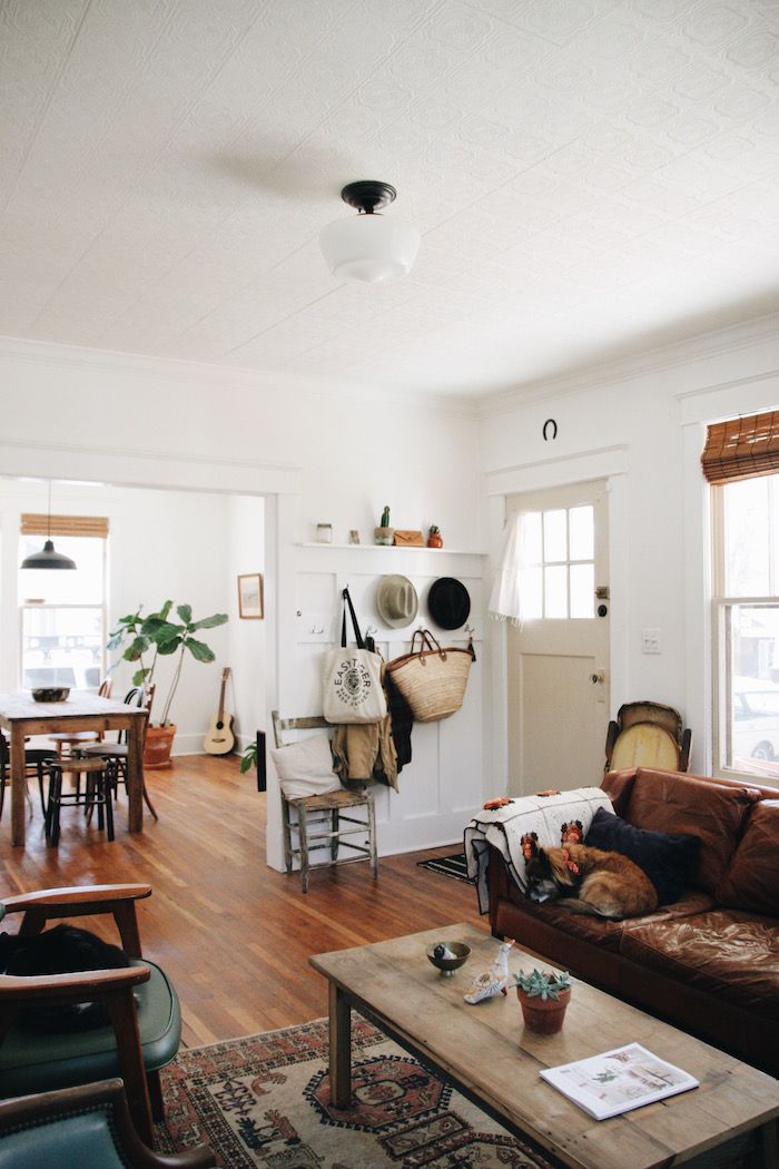 a living room filled with furniture next to a kitchen and dining room table on top of a hard wood floor