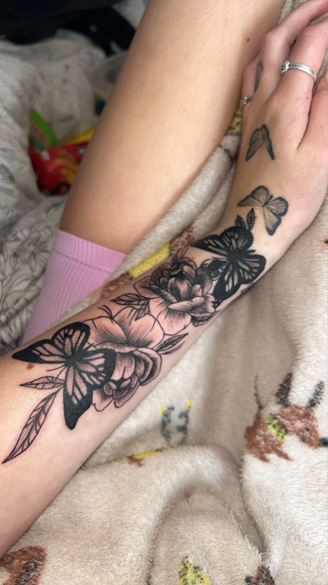 a woman's arm with flowers and butterflies on it