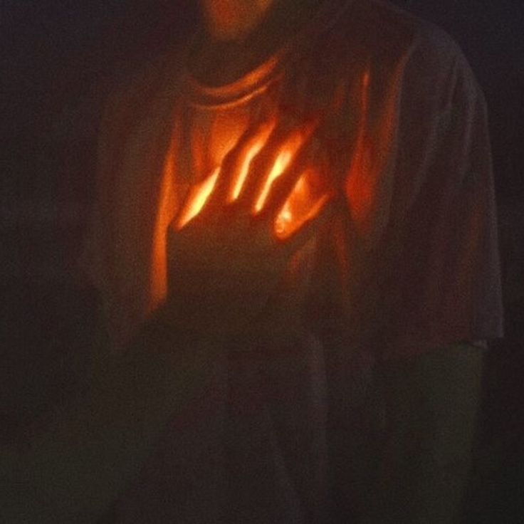 a man holding his hands up in the air with glowing light on it's fingers