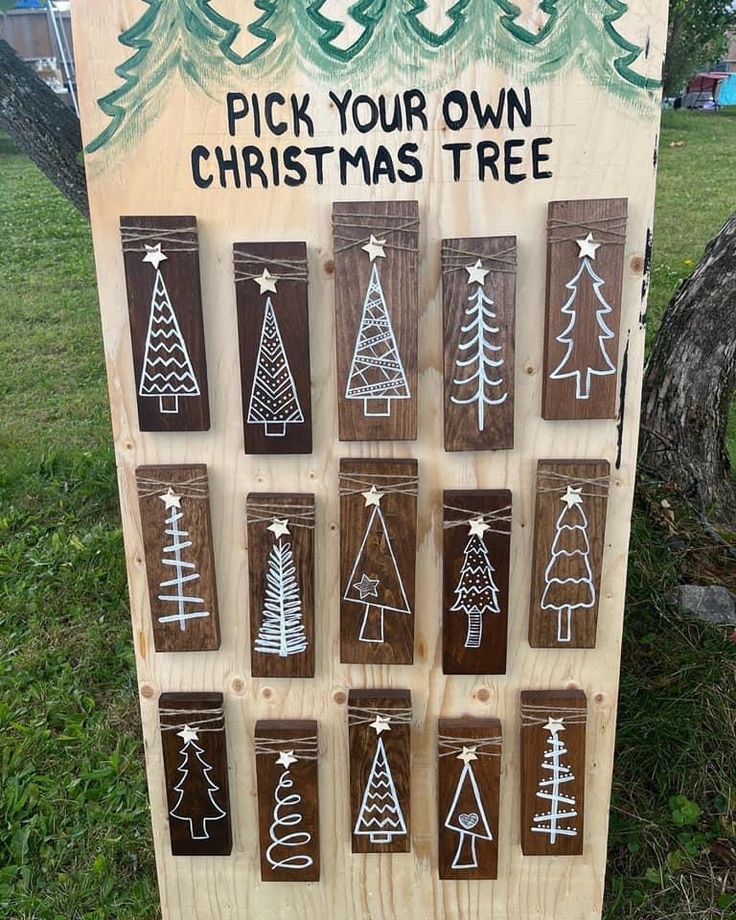 a wooden sign with christmas trees drawn on it