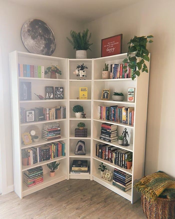 a white book shelf filled with lots of books on top of a hard wood floor