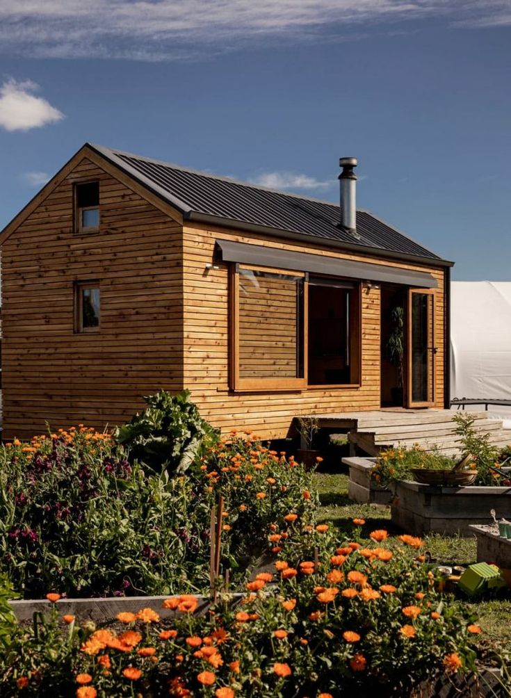 a small wooden house sitting on top of a lush green field