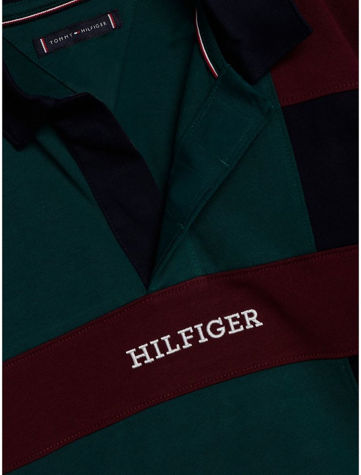 Tommy Hilfiger boys' polo. The varsity-inspired colorblock design adds a sporty touch to this pure cotton polo shirt, finished with a contrast collar and the Hilfiger monotype logo. Part of our Adaptive Collection, designed for ease of dressing in classic Tommy style.  Material: 100% Transitional Cotton ,  In-conversion. Green Cotton Sporty Polo Shirt, Green Sporty Cotton Polo Shirt, Sporty Green Cotton Polo Shirt, Green Cotton Polo Shirt With Ribbed Collar, Sporty Collared Polo Shirt With Logo Print, Sporty Tops With Polo Collar And Contrast Collar, Sporty Cotton Polo Shirt With Logo Print, Green Polo Collar Top With Contrast Stripes, Sporty Cotton Polo Shirt With Collared Neckline