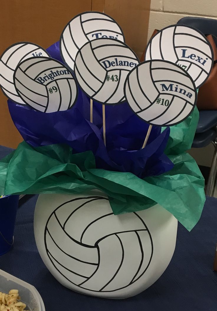 there are many volleyballs on the table with some snacks in front of them,