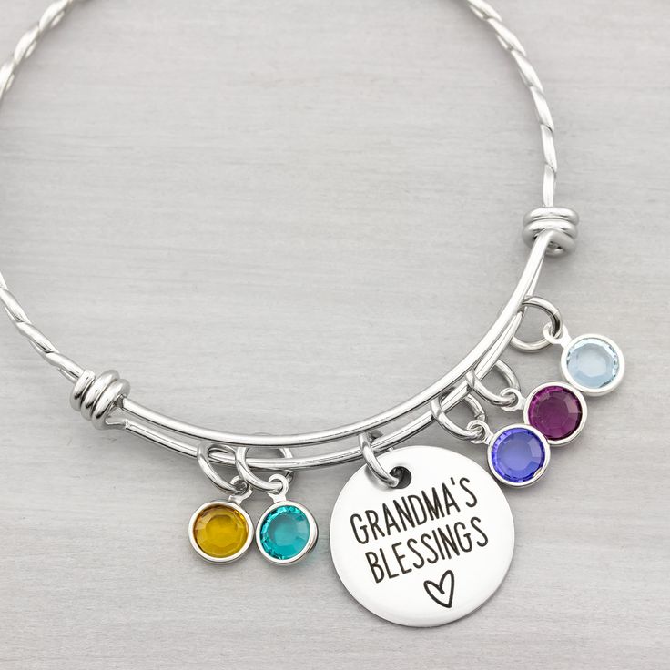 This grandmas blessings birthstone bangle bracelet makes a great keepsake for years to come. You can add birthstones later as needed. Two variations of this personalized bracelet are available: Smooth or twisted. INCLUDES: ♥ 3/4" disc with saying - Grandma's Blessings, Nana's Loves, Blessed Grandma, etc ♥ swarovski birthstone charms -choose number needed from pull down menu ♥ expandable stainless steel bangle bracelet (twisted 1st and 2nd pic, smooth 3rd pic Engraved for a permanent design that Adjustable Bangle Bracelets With Birthstone, Mother's Day Round Birthstone Charm Bracelet, Hand-strung Beaded Bracelets For May Birthstone, Hand-strung Bracelets As May Birthstone Gifts, Personalized Bangle Charm Bracelet For Mother's Day, Stamped Necklaces, Personalised Bangle, Stainless Steel Bangles, Birthstone Bracelets