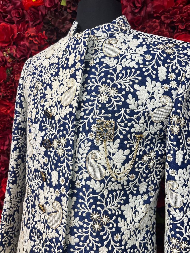 Step into sophistication with the Hardik Sherwani, a perfect blend of tradition and modern style. This navy blue sherwani, adorned with intricate white floral embroidery, exudes luxury and refinement, ideal for grooms or special occasions. Key Features: Elegant Design: Navy blue base with detailed white floral embroidery. High Collar: Adds a touch of classic elegance. Premium Quality Fabric: Ensures comfort and a perfect fit. Ideal for Weddings & Celebrations: Perfect for making a memorable stat Designer Floral Embroidered Kurta For Reception, Blue Sherwani With Intricate Embroidery For Ceremonial Wear, Blue Sherwani With Intricate Embroidery For Ceremonial Occasion, Designer Blue Bandhgala, Designer Traditional Wear With Floral Embroidery For Ceremonial Events, Designer Traditional Bandhgala With Floral Print, Designer Ceremonial Traditional Wear With Floral Embroidery, Designer Blue Kurta For Formal Occasions, Designer Blue Traditional Wear With Resham Embroidery