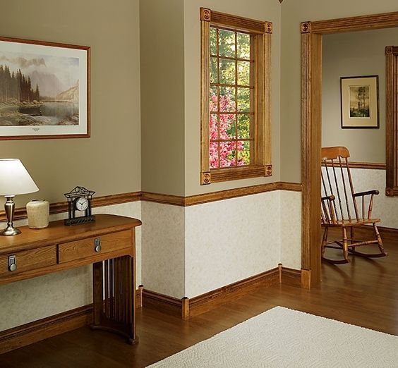 a room with a desk, rocking chair and pictures on the wall in front of it