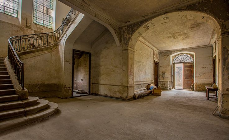 an empty room with stairs and windows