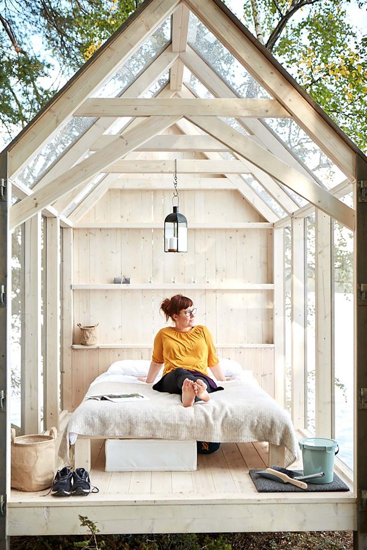 a woman sitting on top of a bed in a wooden structure