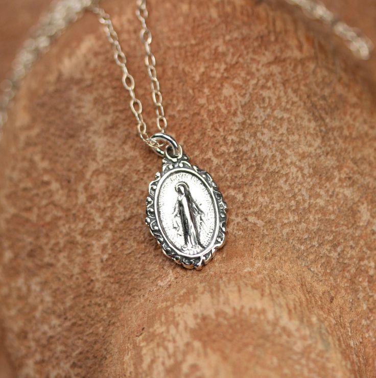 Sterling silver virgin mary necklace - religious necklace - catholic necklace - our lady necklace - virgin mary jewelry A sterling silver virgin mary hang pendant hanging on a 16 inch sterling silver chain. Please feel free to select a different length chain if you prefer. More from BubuRuby? https://www.etsy.com/shop/BubuRuby?ref=hdr_shop_menu Looking for other charm necklaces? https://www.etsy.com/shop/BubuRuby?section_id=12318467 More crystals and healers? http://www.etsy.com/shop/BubuRuby?se Dainty Silver Crucifix Necklace, Silver Jewelry With Miraculous Medal For Gift, Silver Miraculous Medal Jewelry As Gift, Silver Crucifix Necklace With Charms, Silver Necklace With Miraculous Medal For Gift, Silver Necklace With Miraculous Medal As Gift, Dainty Silver Necklace With Miraculous Medal, Silver Miraculous Medal Round Pendant, Silver Our Lady Of Guadalupe Pendant Jewelry