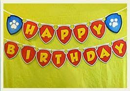 a happy birthday banner with paw prints on it in front of a yellow backdrop that says happy birthday