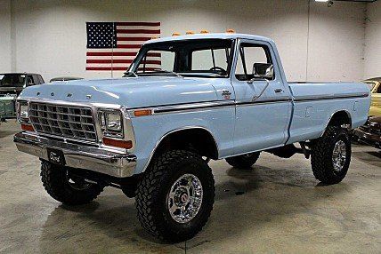 an old blue pickup truck parked in a garage