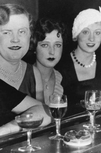 three women sitting at a bar with wine glasses