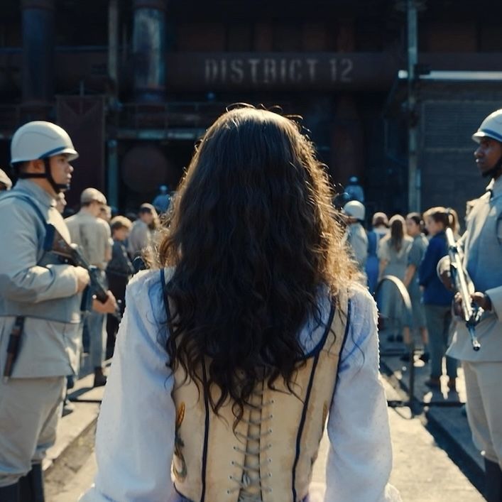 a group of people standing in front of a building with helmets on and one woman wearing a white dress