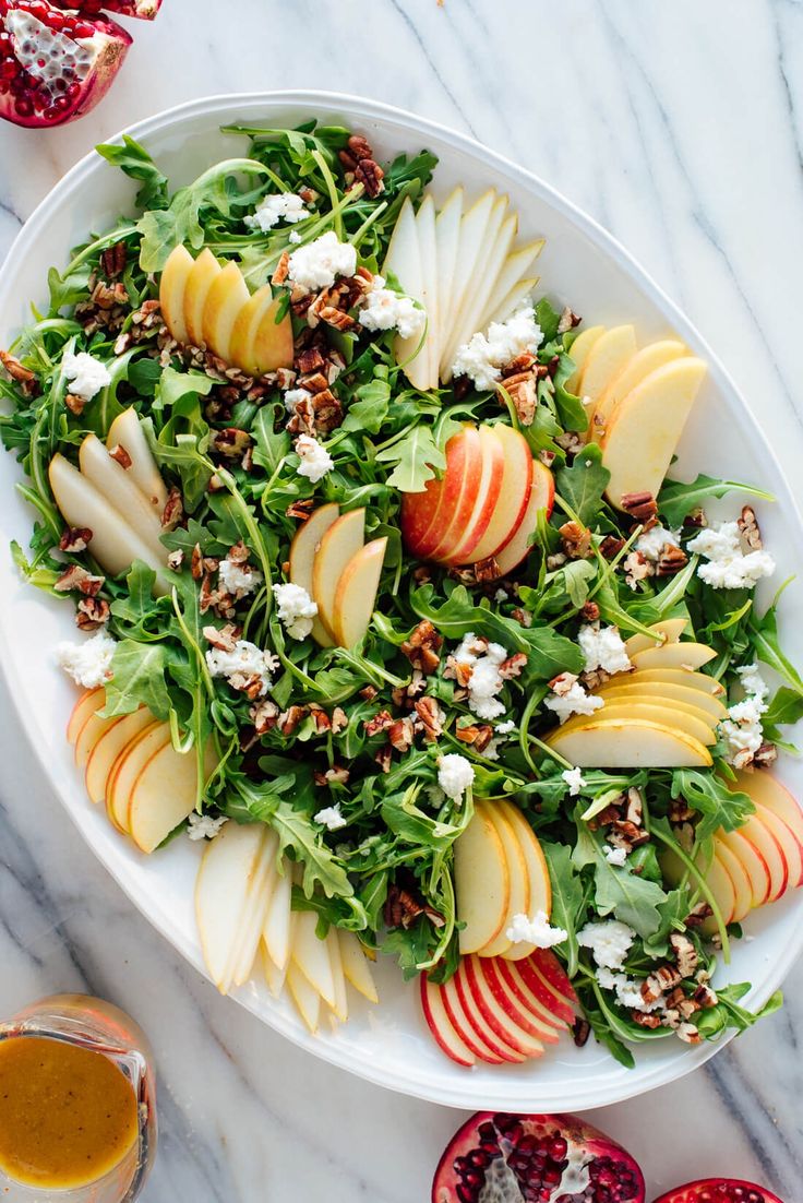 a white plate topped with sliced apples and salad