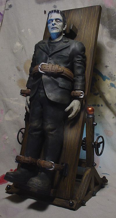 a statue of a man sitting on top of a wooden chair next to a wall