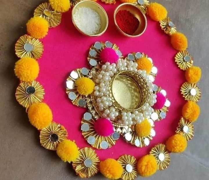 a pink tray with yellow and white pom poms