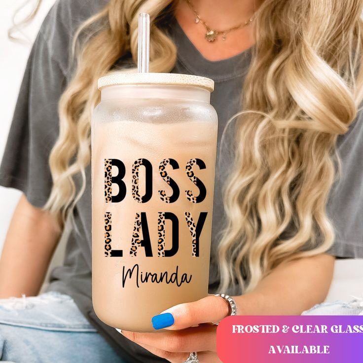 a woman holding a drink with the words boss lady in black and white on it