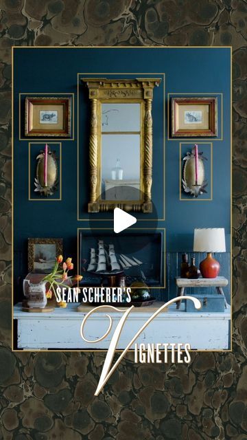 a blue room with pictures on the wall and a gold framed mirror above it that says seam scheeer's vignettes