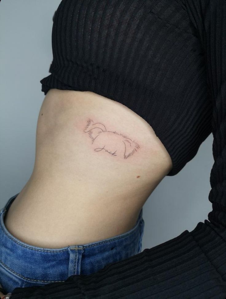 a woman's stomach with a small dog tattoo on the side of her belly