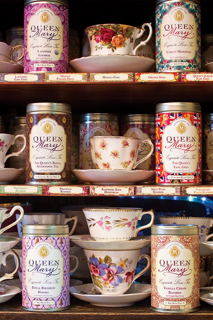 tea cups and saucers are on display in a store shelf, with other items behind them