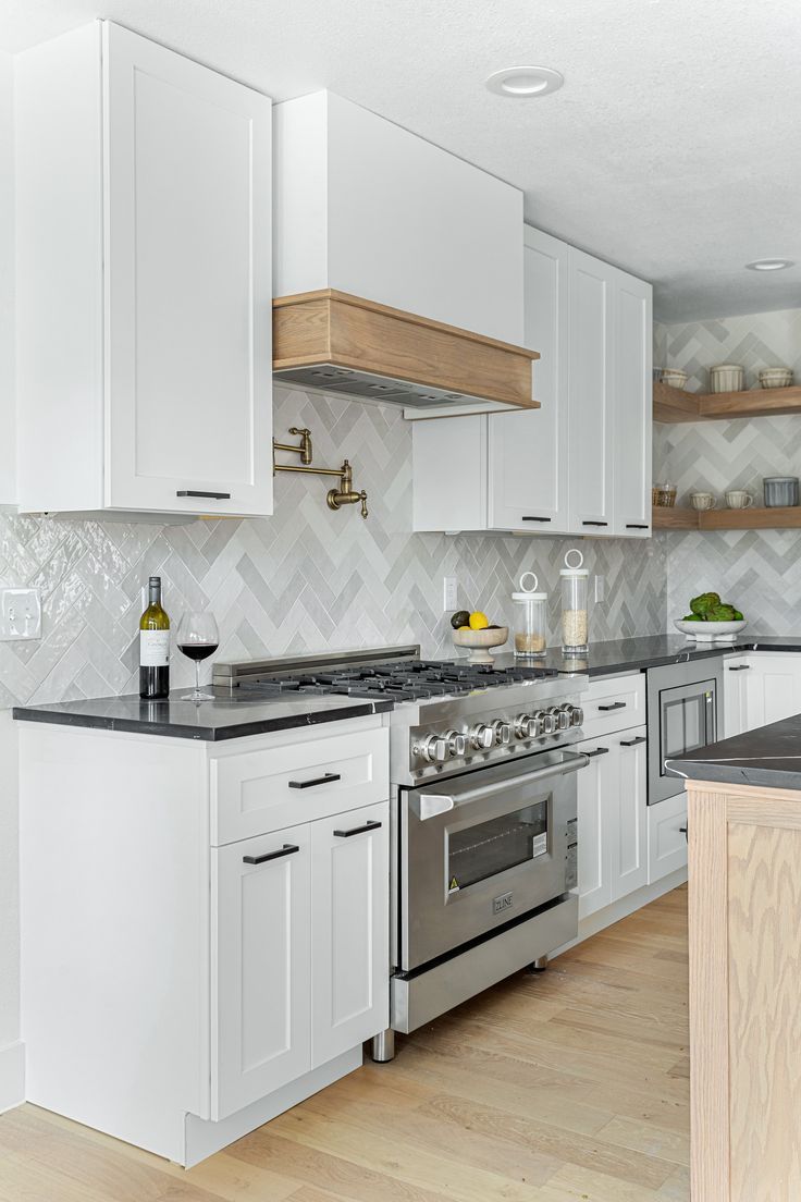 a kitchen with white cabinets and stainless steel appliances