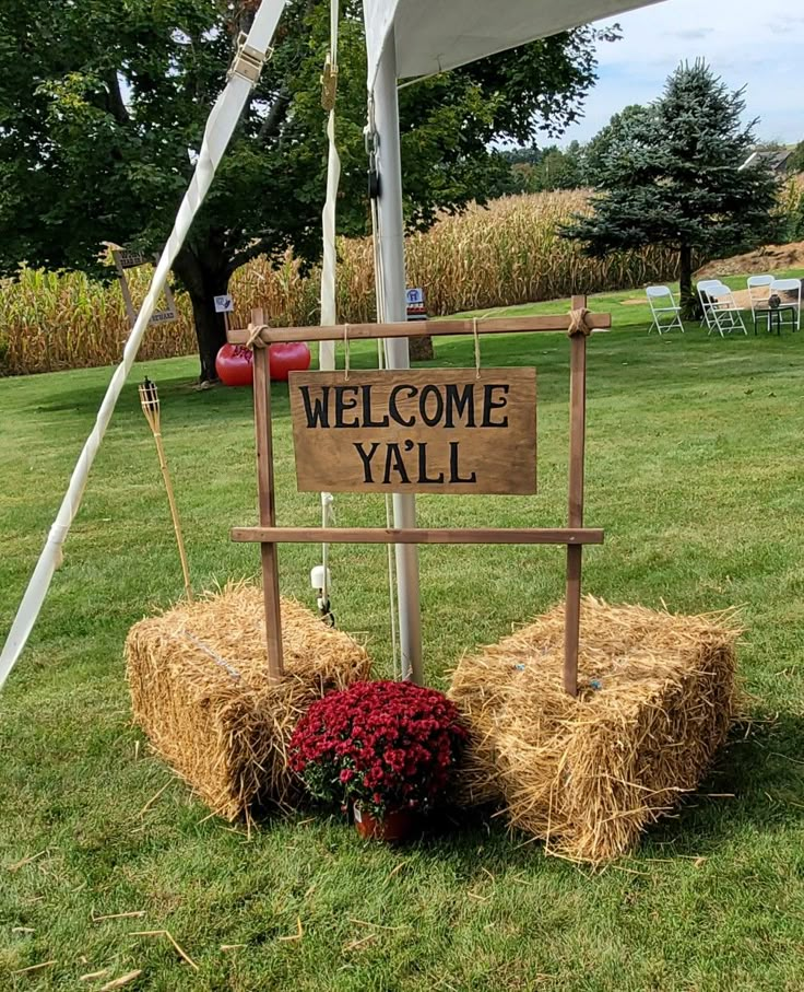 a welcome yall sign sitting on top of hay bales