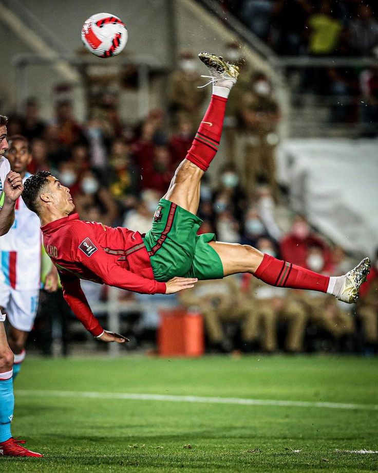 a soccer player is in mid air after kicking the ball