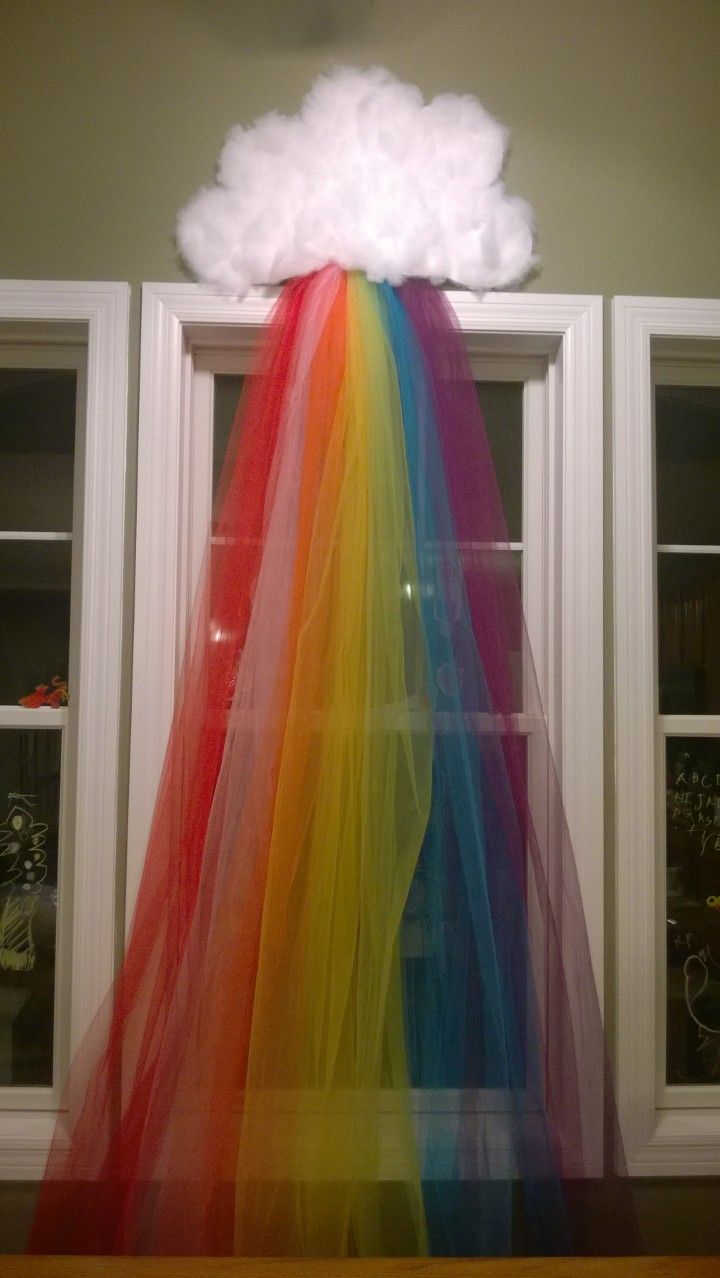 a rainbow colored tulle skirt with a cloud on top in front of two windows