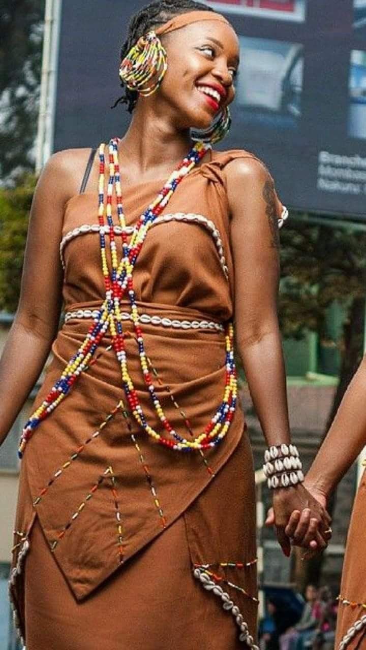 two women dressed in african clothing holding hands