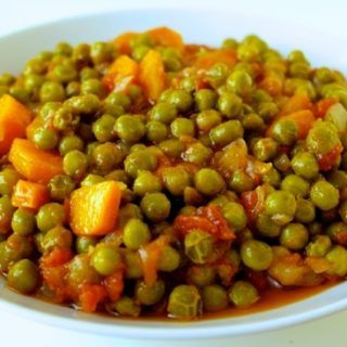 a white bowl filled with peas and carrots