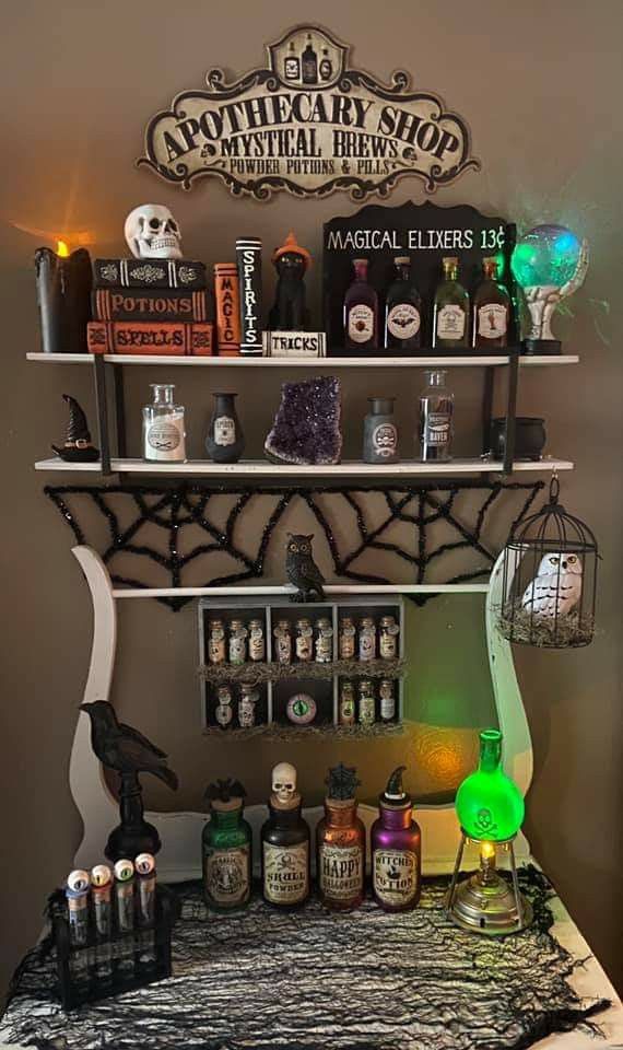 a table topped with lots of halloween decorations and bottles on top of it's shelves