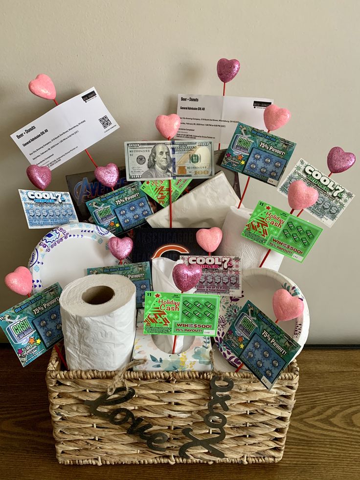 a basket filled with toilet paper, candy and other items on top of a wooden table