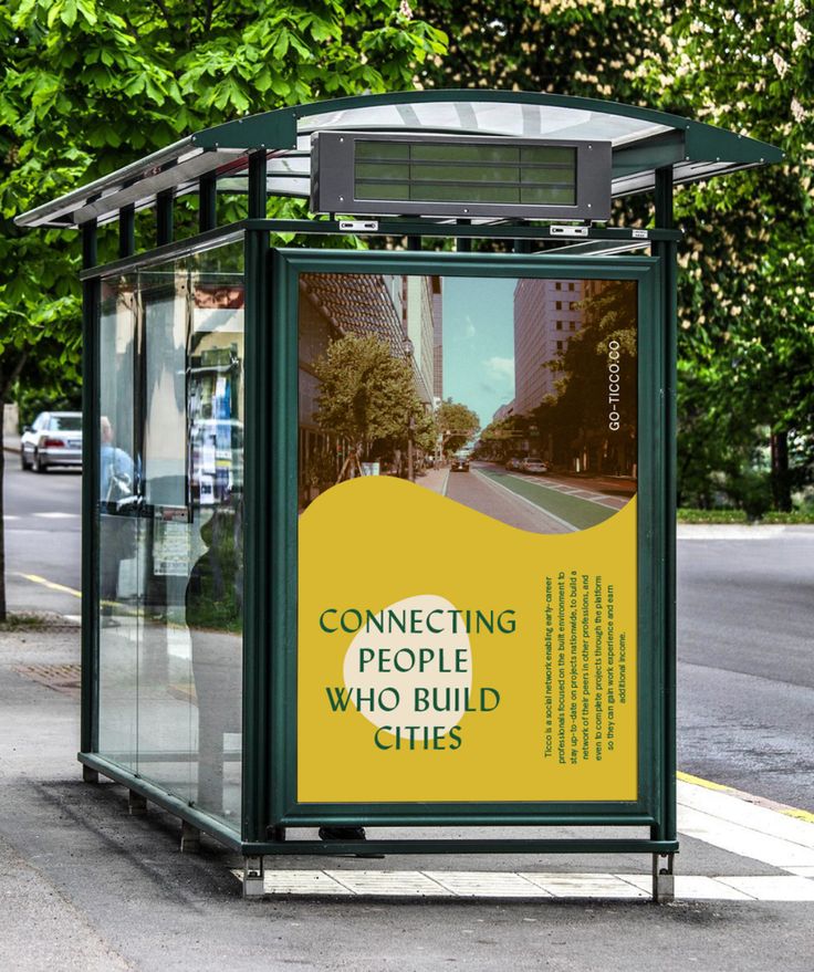 a bus stop sitting on the side of a road next to a tree filled street