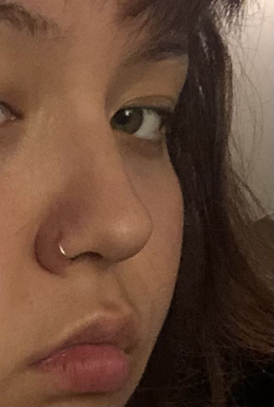 a close up of a woman's nose and nose piercing