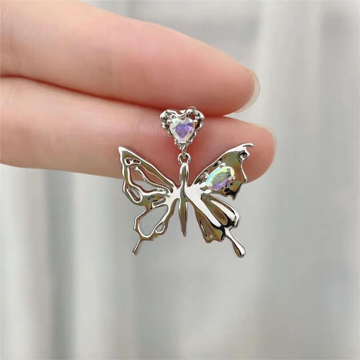 Description: Geometric Dangling Butterfly Earrings Specifications:Size: 27 mm * 22 mmWeight: 7 g/pairMaterial: Copper, Rhinestone, SilverColor: Silver "Flutter into style with these Geometric Dangling Butterfly Earrings! These unique earrings add a touch of whimsy to any outfit while the geometric design adds a modern edge. Get ready to turn heads and spread your wings with these playful accessories. 🦋" Silver Alloy Crystal Earrings, Nickel-free Butterfly Jewelry For Party, Silver Drop Earrings With Butterfly Charm, Trendy Silver Metal Crystal Earrings, Silver Butterfly Metal Jewelry, Trendy Metal Butterfly Jewelry, Silver Metal Butterfly Jewelry, Silver Butterfly Jewelry For Pierced Ears, Silver Jewelry With Butterfly Charm