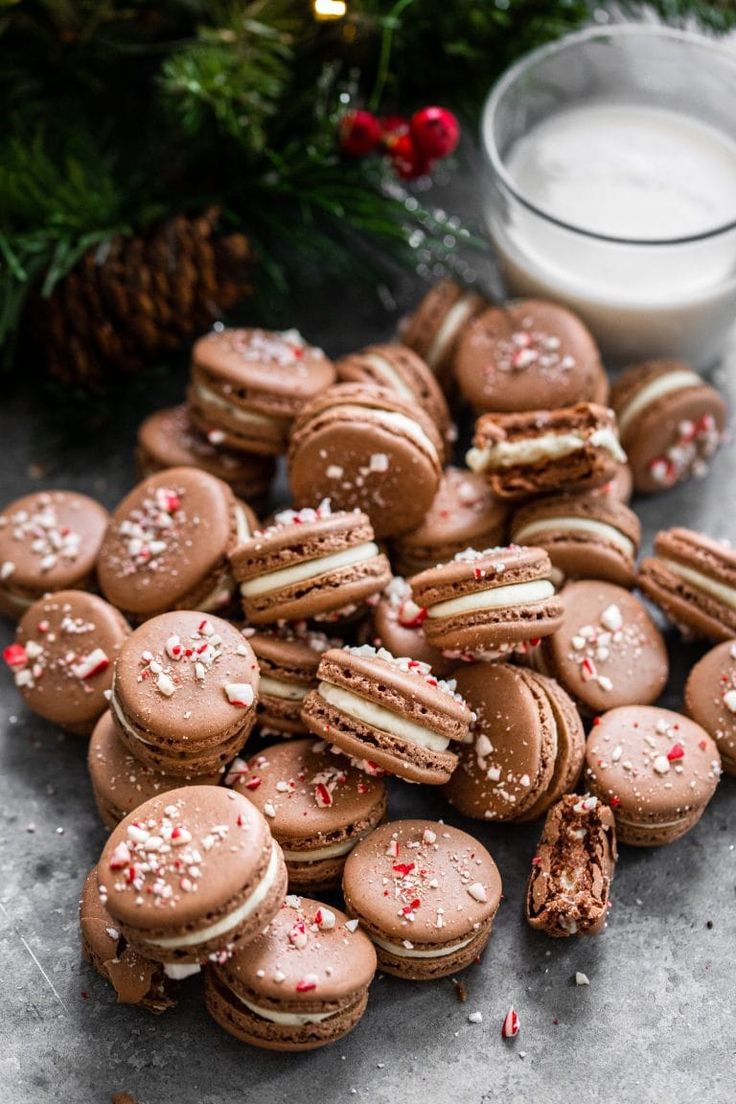 a pile of cookies sitting on top of a table next to a glass of milk