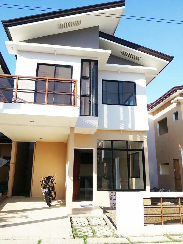 a motorcycle is parked in front of a two story house with balconies on the second floor