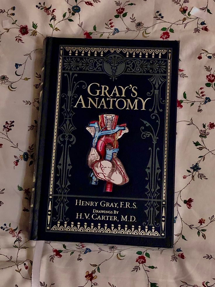 the book gray's anatomy is laying on a bed