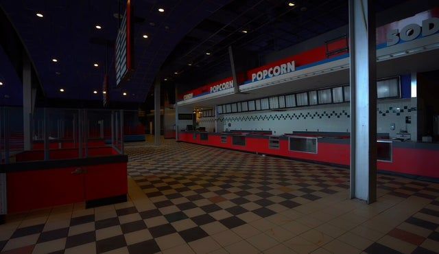 an empty diner with checkered flooring and red booths on the sidelines at night