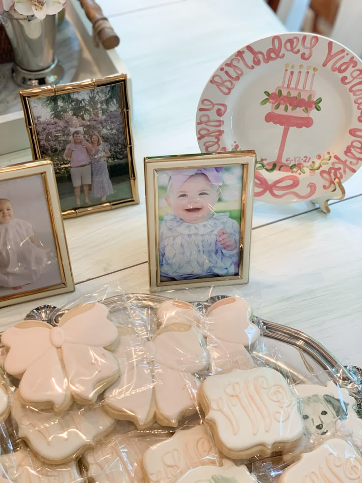 some cookies are on a table with pictures and other items in front of the plate