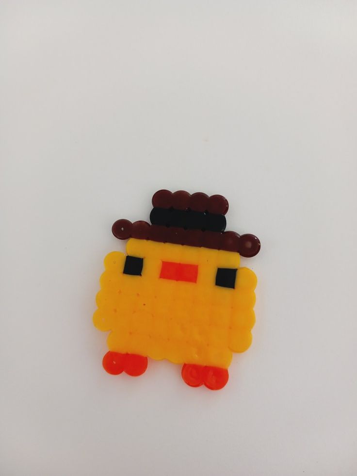 a piece of food that is shaped like a yellow robot with a hat on it