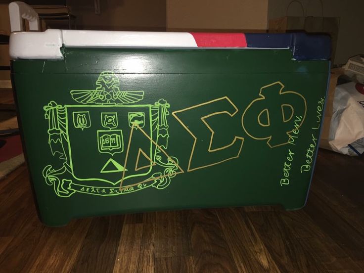 a large green cooler with the word phi painted on it's side, sitting on a hard wood floor