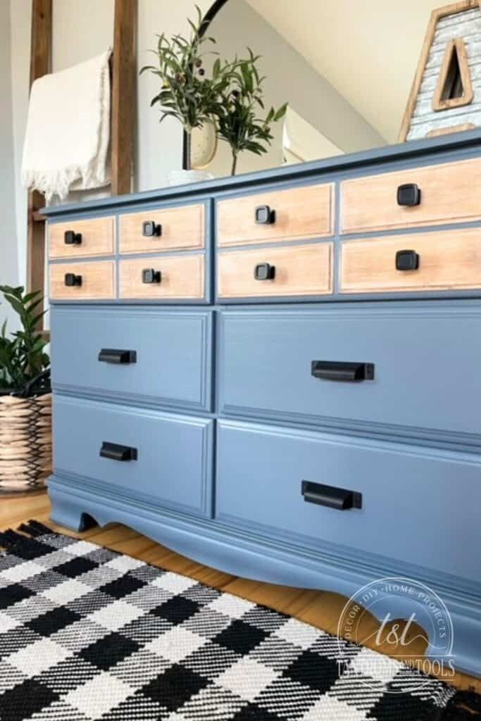 a blue dresser sitting on top of a wooden floor next to a potted plant