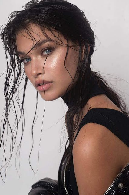 a woman with wet hair posing for the camera