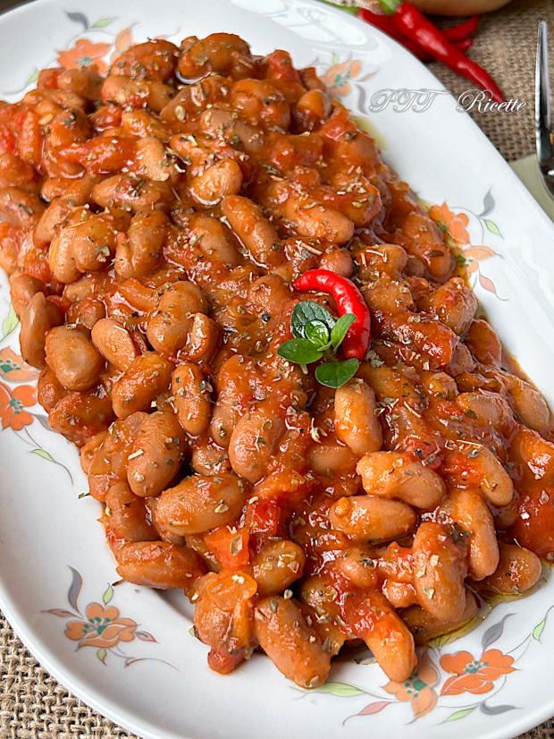 a white plate topped with beans covered in sauce