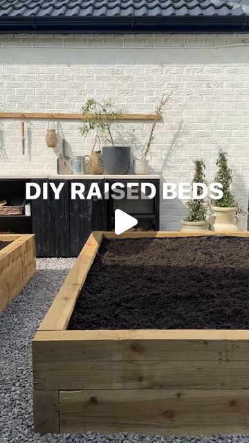 an outdoor garden area with raised beds and potted plants